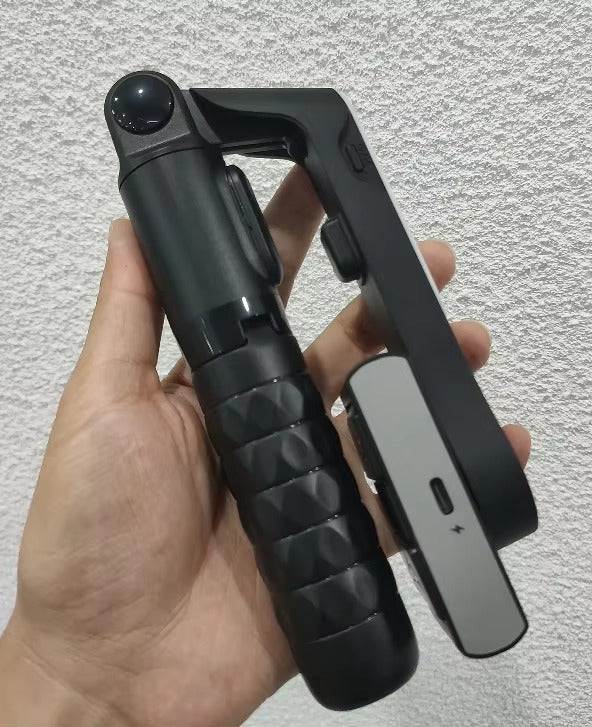 Black and gray tool held in a hand against a light gray background