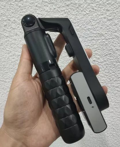 Black and gray tool held in a hand against a light gray background